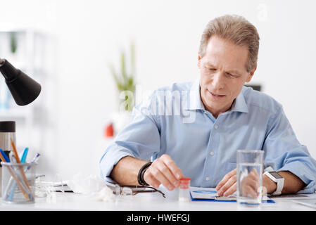 Delighted male person touching jar with tablets Stock Photo