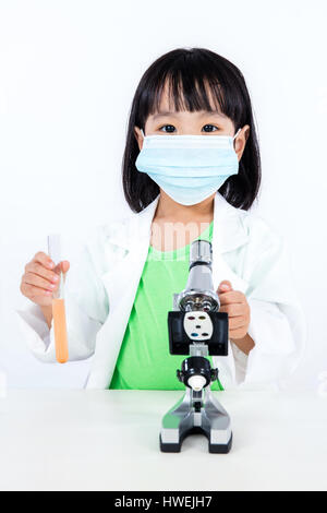 Asian Chinese Little Girl Examining Test Tube With Uniform in isolated white background. Stock Photo