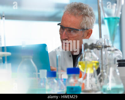 Scientist examining data on a laptop computer from an experiment in the laboratory Stock Photo