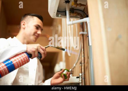 https://l450v.alamy.com/450v/hwemjj/young-male-trainee-plumber-using-blow-torch-on-pipework-in-college-hwemjj.jpg