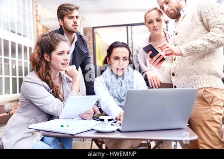 Businesswomen and businessmen having team meeting on office patio Stock Photo