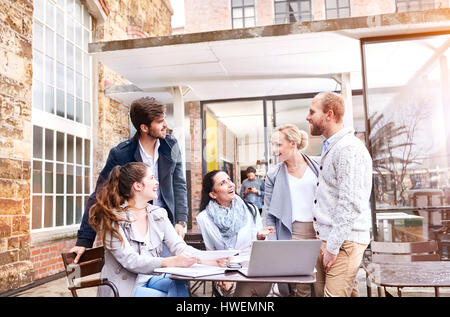 Businesswomen and businessmen having team discussion at meeting on office patio Stock Photo
