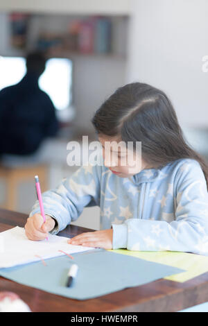 Girl doing homework at kitchen table Stock Photo