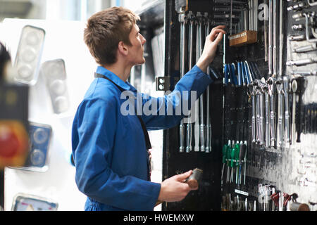 College mechanic student selecting tools from repair garage tool kit Stock Photo