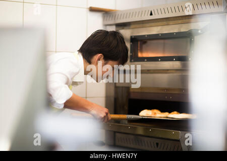 Young woman cooking food in fast food shop Stock Photo