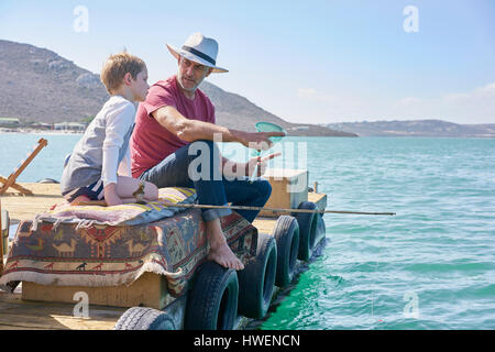 Grandfather and grandson fishing on houseboat sun deck, Kraalbaai, South Africa Stock Photo