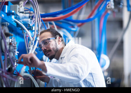 Scientist adjusting heavy machinery Stock Photo