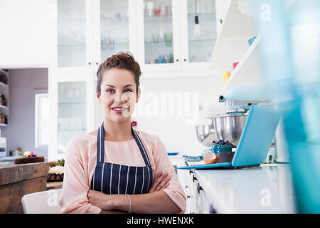Portrait of young female baker in kitchen Stock Photo