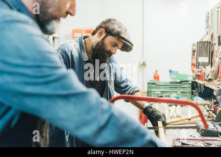 Two mature men, working in garage Stock Photo
