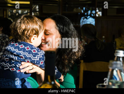 Mature woman face to face with baby son in cafe Stock Photo
