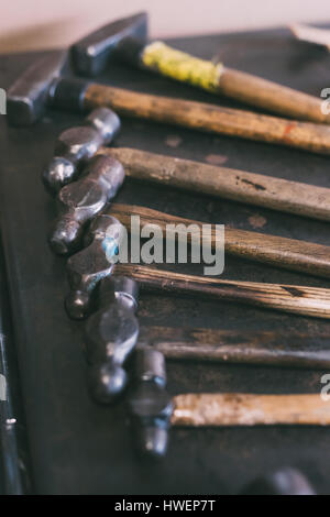 Row of hammers on forge workbench Stock Photo