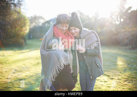 Grandmother and granddaughters hugging in garden Stock Photo
