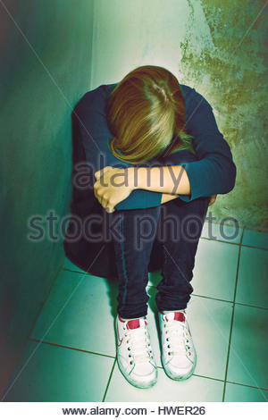 Scared girl sitting in the corner Stock Photo: 172528564 - Alamy