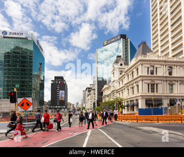 AUCKLAND, NEW ZEALAND - FEBRUARY 22, 2017: Pedestrains cross a street in the busy Auckland central business district in New Zealand largest city on a  Stock Photo