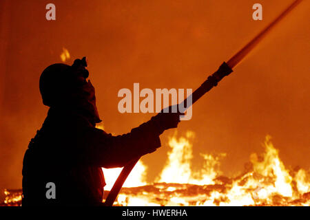 LAKE ARROWHEAD ,CA , UNITED STATES :   A firefighter uses a water hose on a burning home in Lake Arrowhead, California during wild fires there on Wednesday  29 October, 2003. Wildfires in California have burnt over a 1,000 homes and killed over 20 people in the last week..Photo by Francis Specker Stock Photo