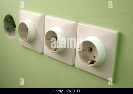 Three white European 220V power socket on green wall in Novi Sad, Serbia Stock Photo
