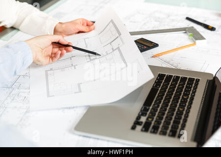 Young female architect and designer working on blueprint project of new apartments. Photo concept of work on technical drawings Stock Photo