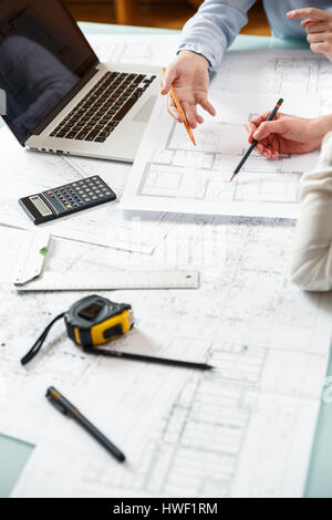 Young female architect and designer working on blueprint project of new apartments. Photo concept of work on technical drawings Stock Photo