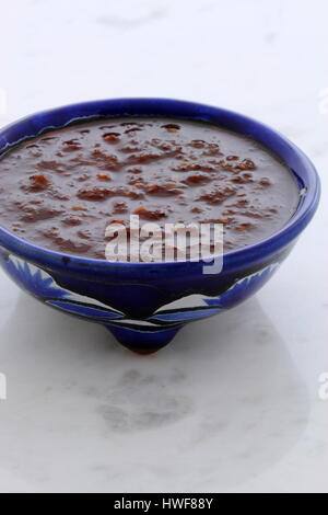 Artisan mexican hot salsa in vintage talavera bowl, with a delicious fresh hot flavor,  on vintage carrara marble table. Stock Photo