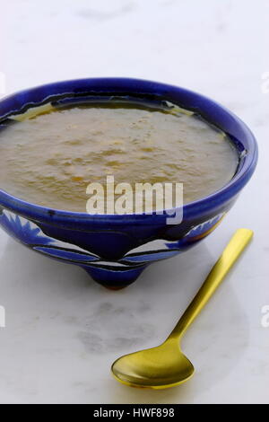 Artisan mexican tomatillo salsa in vintage talavera bowl, with a delicious fresh hot flavor,  on vintage carrara marble table. Stock Photo