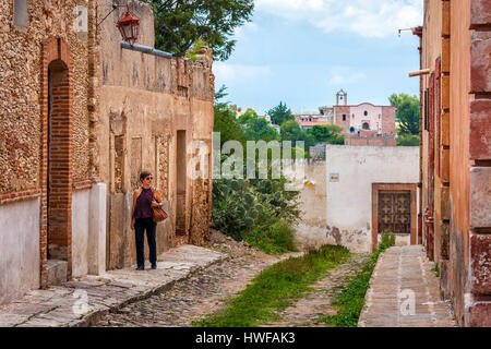 Middle aged female tourist strolls the streets of colonial Mineral de Pozos, Guanajuato, Mexico. Stock Photo