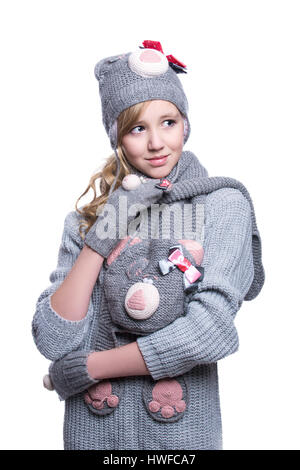 Lovely cheerful teenage girl wearing fuzzy sweater, scarf, mittens and hat isolated on white background. Winter clothes Stock Photo