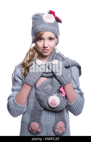 Lovely cheerful teenage girl wearing fuzzy sweater, scarf, mittens and hat isolated on white background. Winter clothes Stock Photo