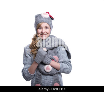 Lovely cheerful teenage girl wearing fuzzy sweater, scarf, mittens and hat isolated on white background. Winter clothes Stock Photo