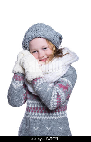 Happy cute kid posing in the studio isolated on white background. Wearing winter clothes. Knitted woolen sweater, scarf, hat and mittens Stock Photo