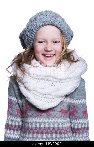 Happy cute kid posing in the studio isolated on white background. Wearing winter clothes. Knitted woolen sweater, scarf, hat and mittens Stock Photo