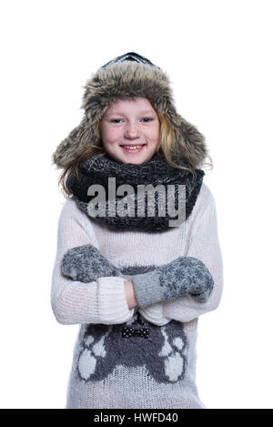 Happy cute kid posing in the studio. Wearing winter clothes. Knitted woolen sweater and mittens. Ear flaps fur cap. Isolated on white background Stock Photo
