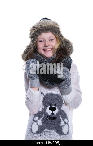 Happy cute kid posing in the studio. Wearing winter clothes. Knitted woolen sweater and mittens. Ear flaps fur cap. Isolated on white background Stock Photo