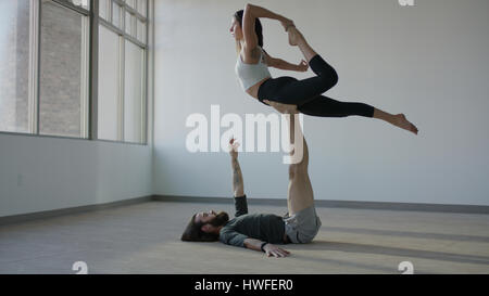 Serene athletic dancer holding partner in mid-air on studio floor Stock Photo