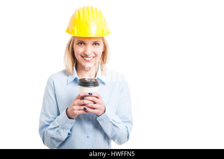 Female engineer wearing helmet holding coffee to go cup and smiling isolated on white background with copy text space Stock Photo
