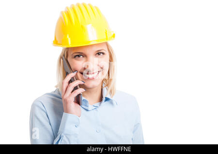 Female engineer wearing helmet talking at phone and smiling isolated on white background with copy text space Stock Photo