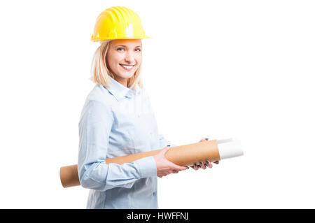 Woman architect wearing yellow helmet holding blueprints and smiling isolated on white background with copy text space Stock Photo