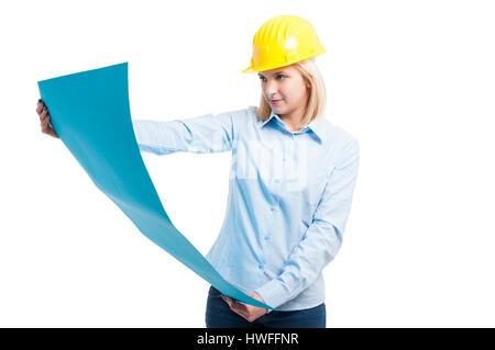 Woman architect wearing yellow helmet looking at blueprints  isolated on white background with copy text space Stock Photo