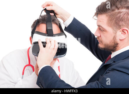 Young entrepreneur putting futuristic device on medic head to experience virtual reality isolated on white Stock Photo