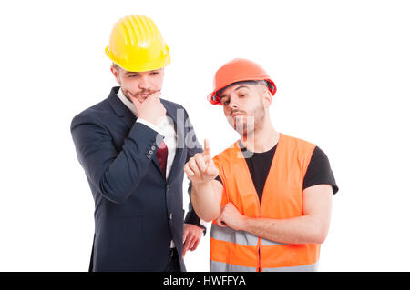 Young builder using an imaginary screen and pressing it on white background Stock Photo