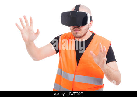 Young builder wearing vr glasses experiencing virtual gaming on white background Stock Photo