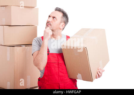 Mover man holding cardboard box making thinking gesture and looking up isolated on white background Stock Photo