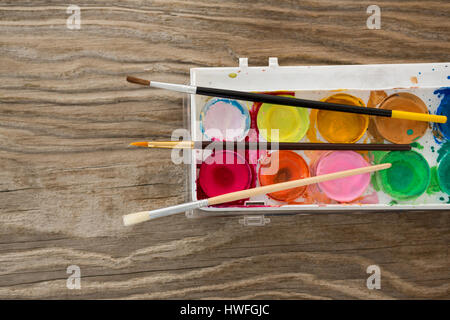 Paintbrushes and palette on wooden surface Stock Photo