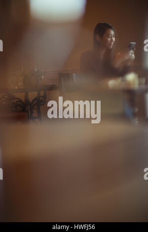 Smiling woman using mobile phone in cafÃƒÂ© Stock Photo