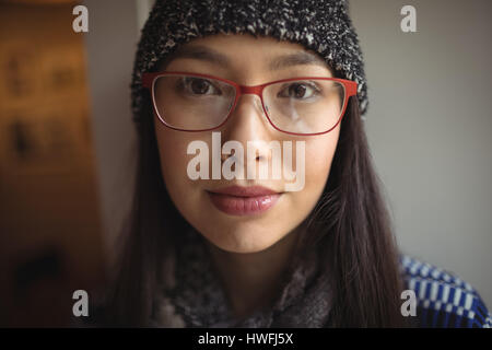 Portrait of beautiful woman wearing cap and spectacles in cafe Stock Photo