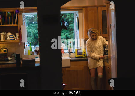Woman preparing coffee in kitchen at home Stock Photo