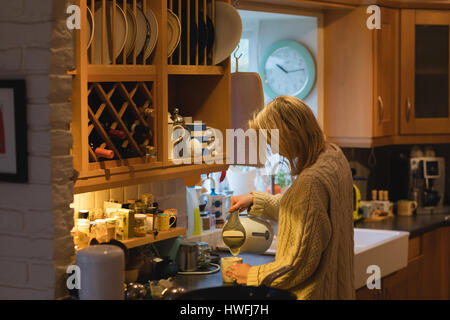 Woman preparing coffee in kitchen at home Stock Photo
