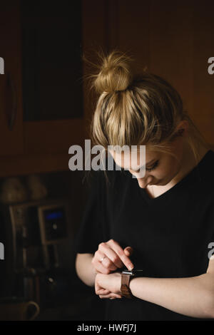 Woman using smart watch at home Stock Photo