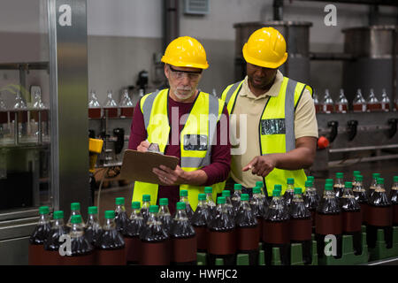 Male workers discussing in juice factory Stock Photo
