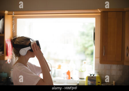 Woman using virtual reality headset at home Stock Photo