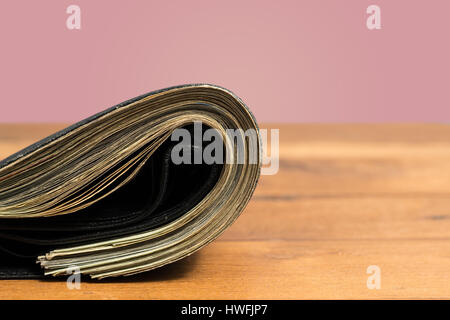 Wad of US dollar bills in black wallet on table Stock Photo